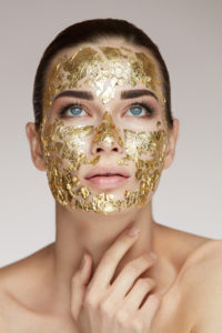 Beauty Gold Mask. Portrait Of Sexy Girl With Golden Mask On Facial Skin Touching Body. Closeup Of Attractive Woman With Smooth Skin And Cosmetic Product On Face. Spa Procedure. High Resolution
